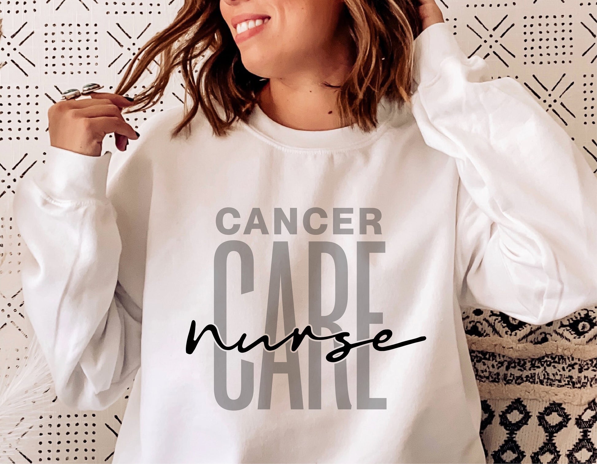 Woman wearing white sweatshirt with 'Cancer Care Nurse' graphic, ideal for oncology nurse SVG projects, digital download resources.