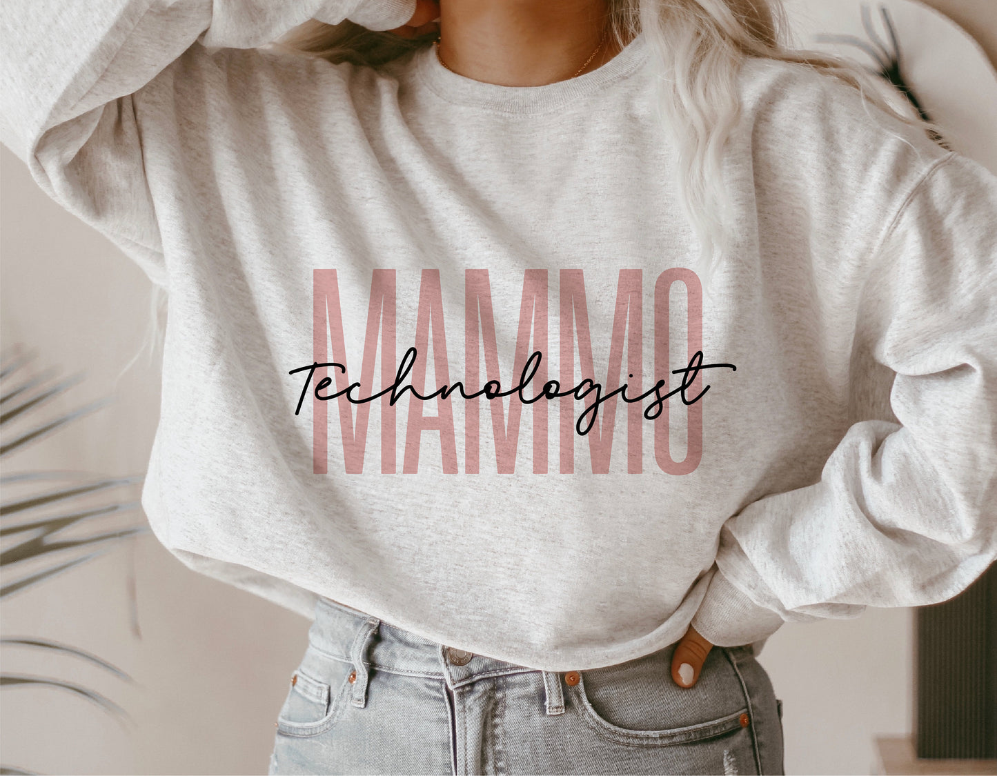 Person wearing a gray sweater with 'Mammo Technologist' text, promoting breast cancer awareness and celebrating radiology experts.
