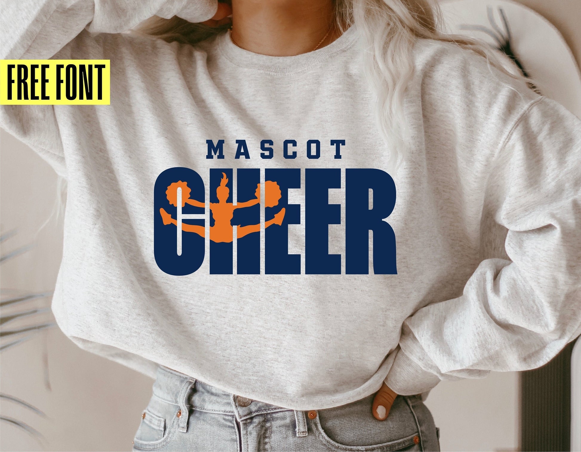 Woman wearing a sweatshirt with 'Mascot CHEER' design in blue and orange, promoting free font download for cheerleader-themed cut files.
