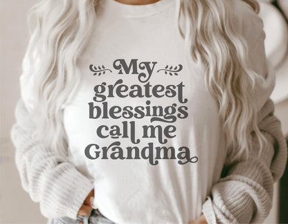 White t-shirt with 'My Greatest Blessings Call Me Grandma' print, perfect for Mother's Day, featuring stylish text design.