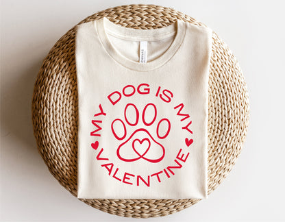 "My Dog Is My Valentine" shirt with red dog paw heart design, perfect for Valentine's Day, displayed on a woven mat.