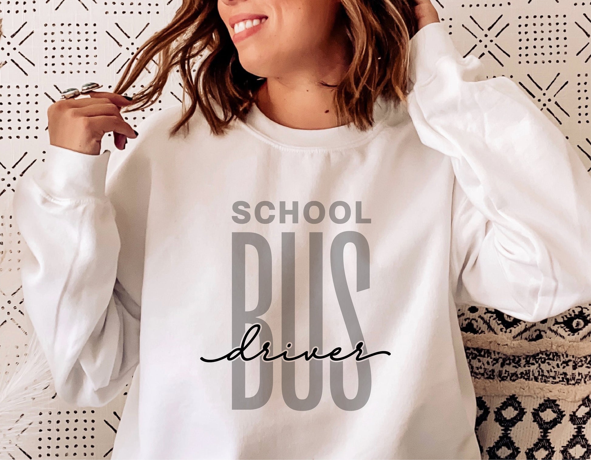 Woman wearing a white sweatshirt with 'School Bus Driver' design, perfect for Cricut crafts and sublimation projects.