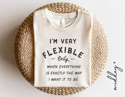 Funny cream t-shirt with 'I'm Very Flexible' text, showcasing sarcastic humor, ideal for mom boss babe style, laid on woven mat.