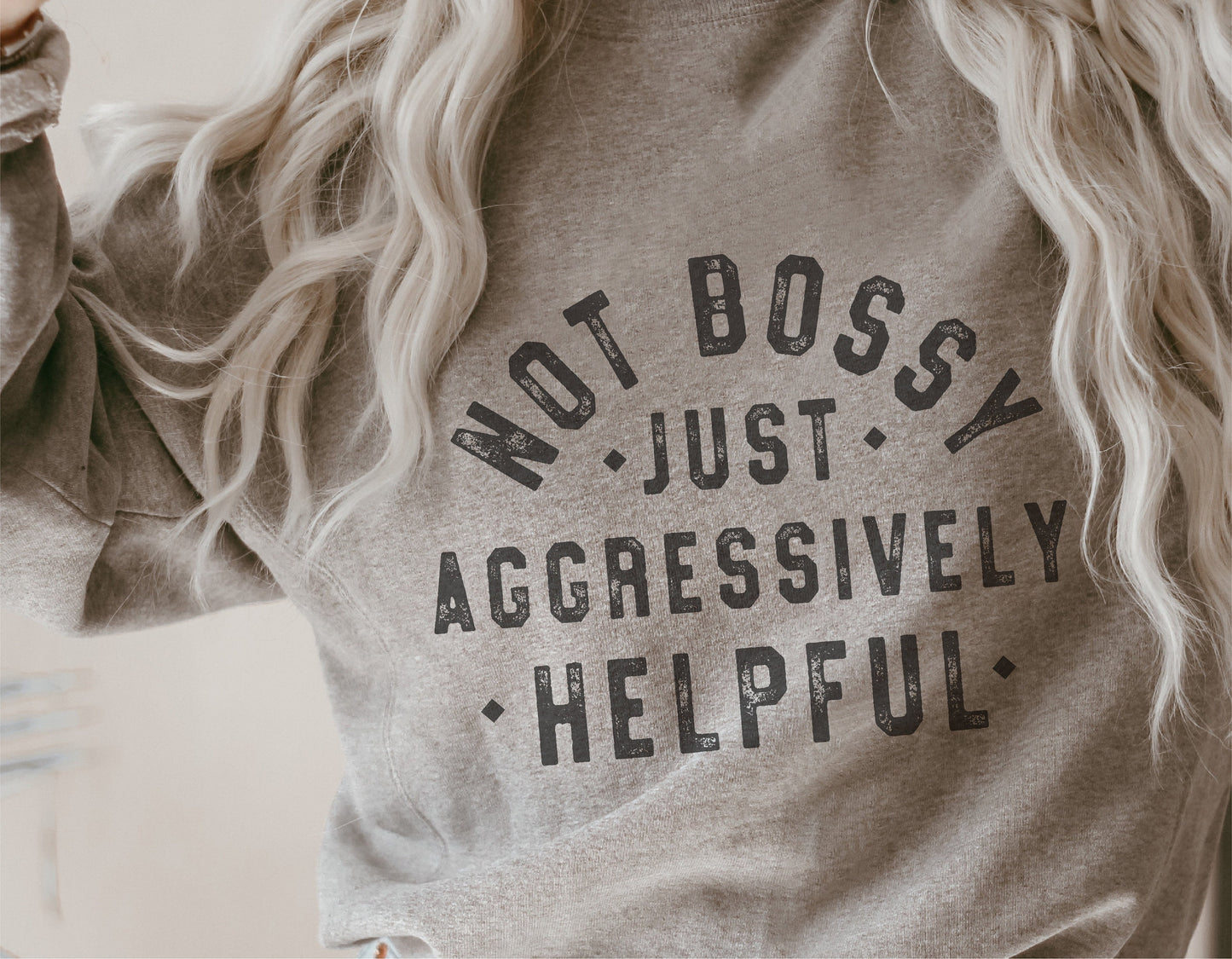 Person wearing a sweatshirt with the text 'Not Bossy Just Aggressively Helpful' printed on it.