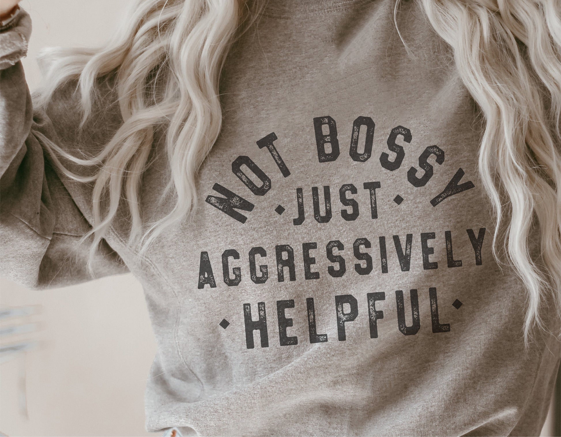 Person wearing a sweatshirt with the text 'Not Bossy Just Aggressively Helpful' printed on it.