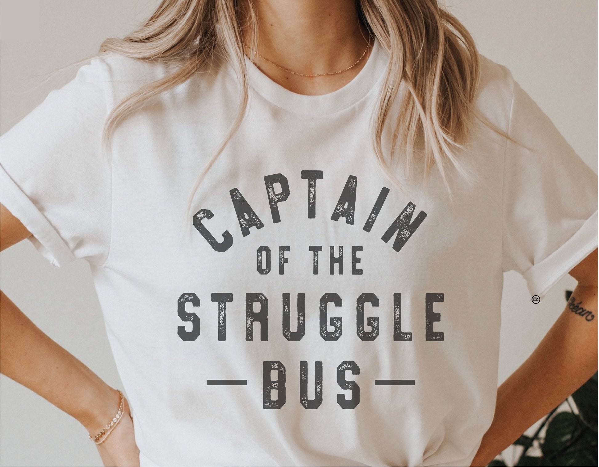 Woman wearing a white t-shirt with 'Captain of the Struggle Bus' text, showcasing a funny SVG design for Cricut and Silhouette projects.