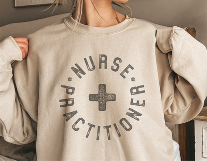 Beige sweatshirt with 'Nurse Practitioner' text and cross graphic, ideal for custom decals and Cricut cut files.