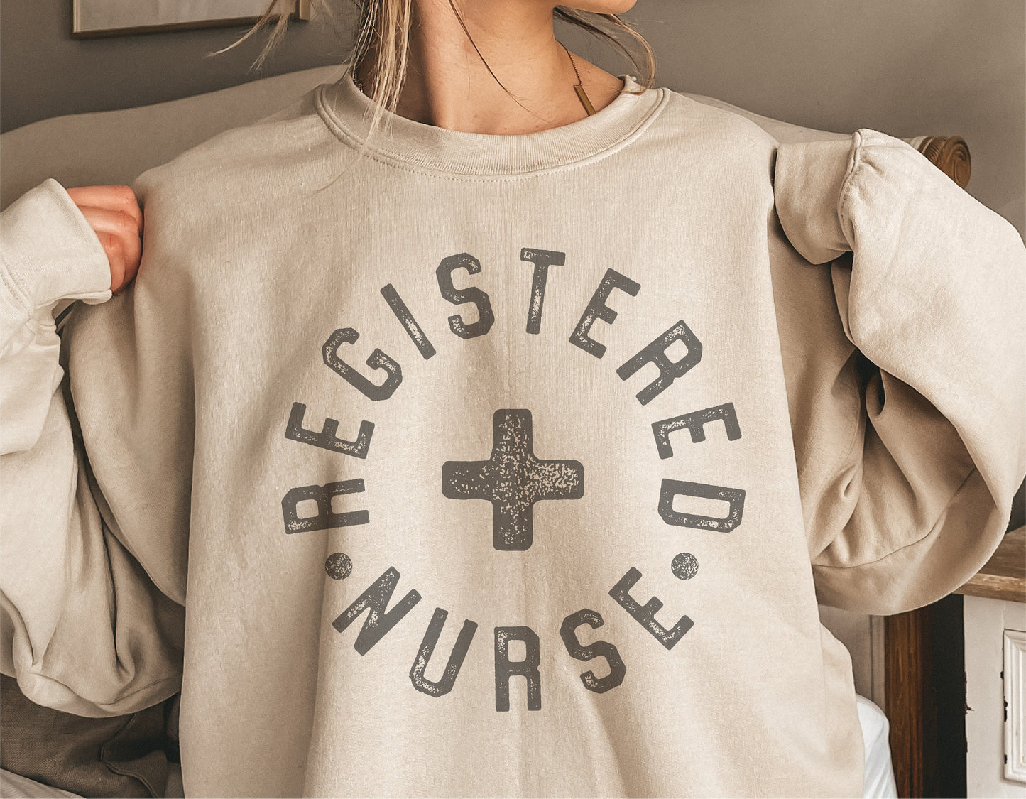 Sweatshirt featuring "Registered Nurse" text with cross symbol, perfect for RN gifts or apparel.