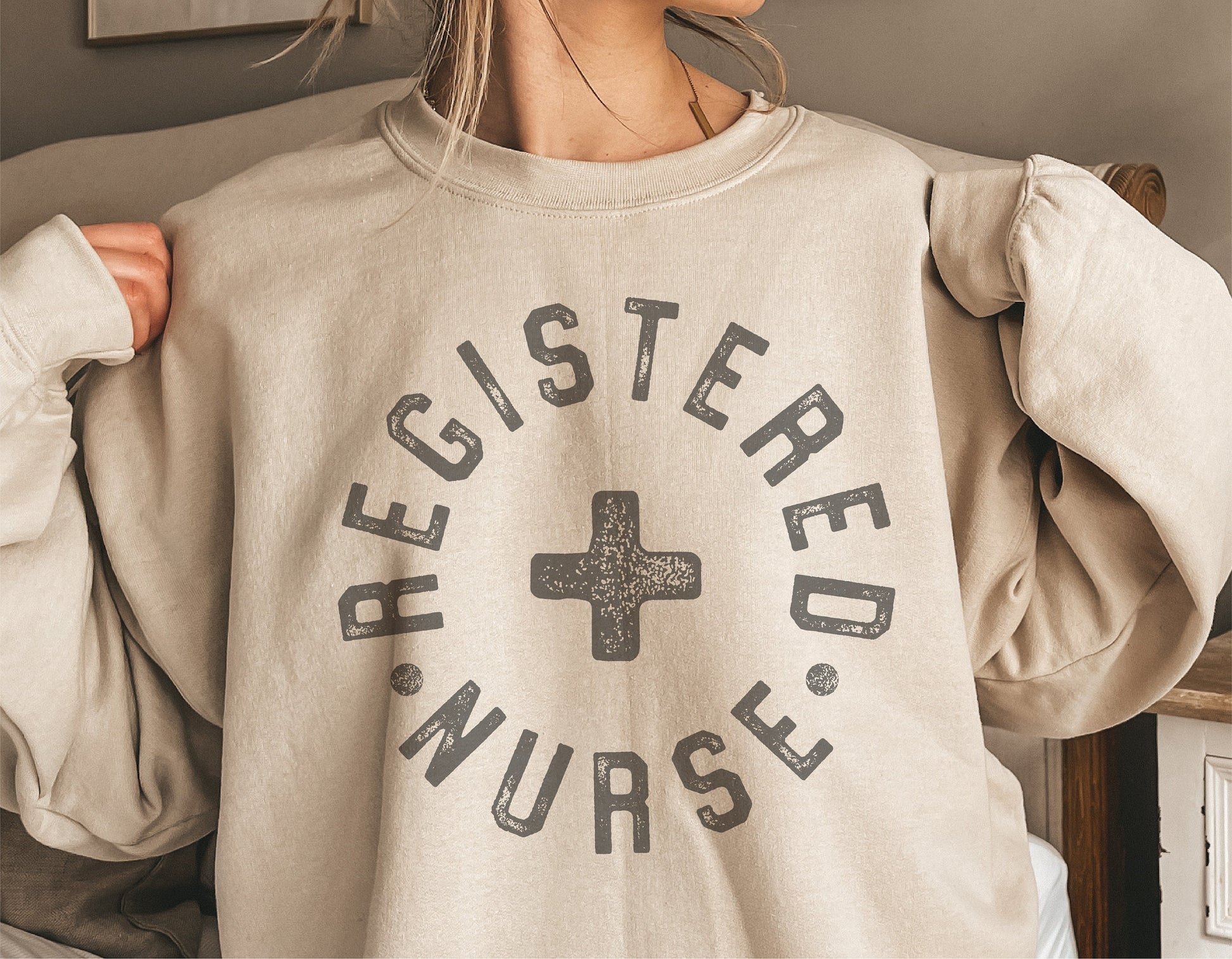 Sweatshirt featuring "Registered Nurse" text with cross symbol, perfect for RN gifts or apparel.