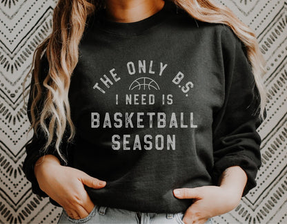 Woman wearing 'The Only B.S. I Need is Basketball Season' black sweatshirt.
