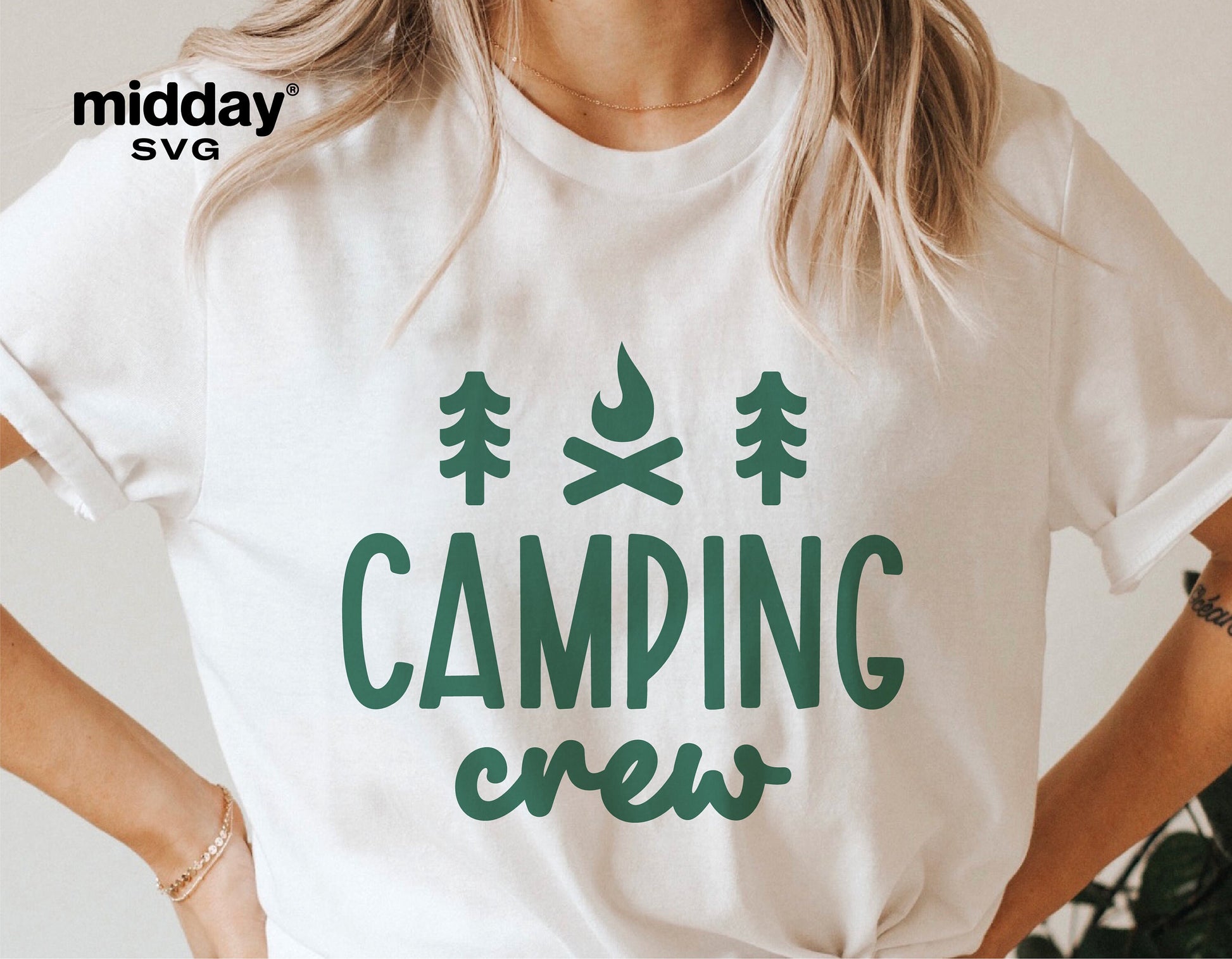 Woman wearing a white t-shirt with green 'Camping Crew' graphic design featuring trees and a campfire, suitable for camping enthusiasts.