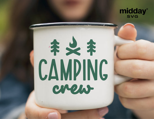 Close-up of a hand holding a white camping mug with 'Camping Crew' design in green, perfect for outdoor enthusiasts and camping trips.