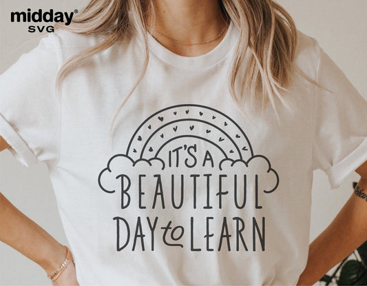 White t-shirt featuring 'It's A Beautiful Day To Learn' SVG design with rainbow for teachers, suitable for Cricut and Silhouette projects.