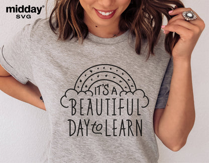 Woman wearing a "It's A Beautiful Day To Learn" teacher shirt with stylish text and rainbow design, ideal for teaching-themed projects.