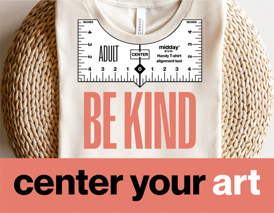 T-shirt with 'Be Kind' design using alignment tool printable, displayed on wicker background with 'center your art' text.