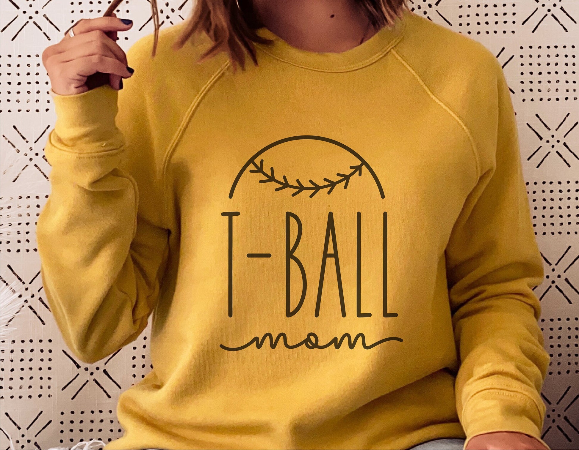 Woman wearing yellow sweatshirt with "T-Ball Mom" design for Cricut and Silhouette projects.