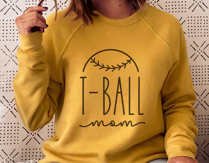 Woman wearing yellow sweatshirt with "T-Ball Mom" design for Cricut and Silhouette projects.