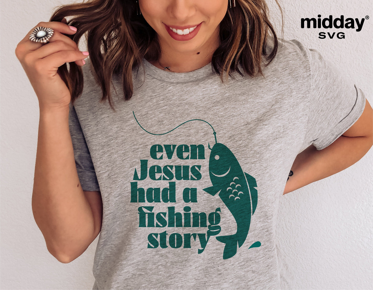 Gray t-shirt with 'Even Jesus had a fishing story' text and fish graphic, Christian SVG design for Cricut. Worn by smiling woman.