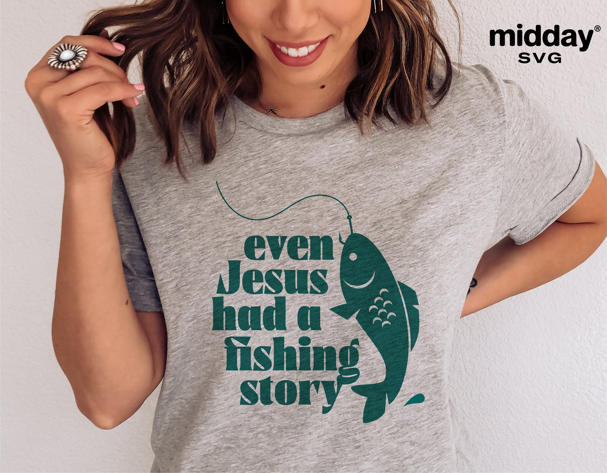 Gray t-shirt with 'Even Jesus had a fishing story' text and fish graphic, Christian SVG design for Cricut. Worn by smiling woman.