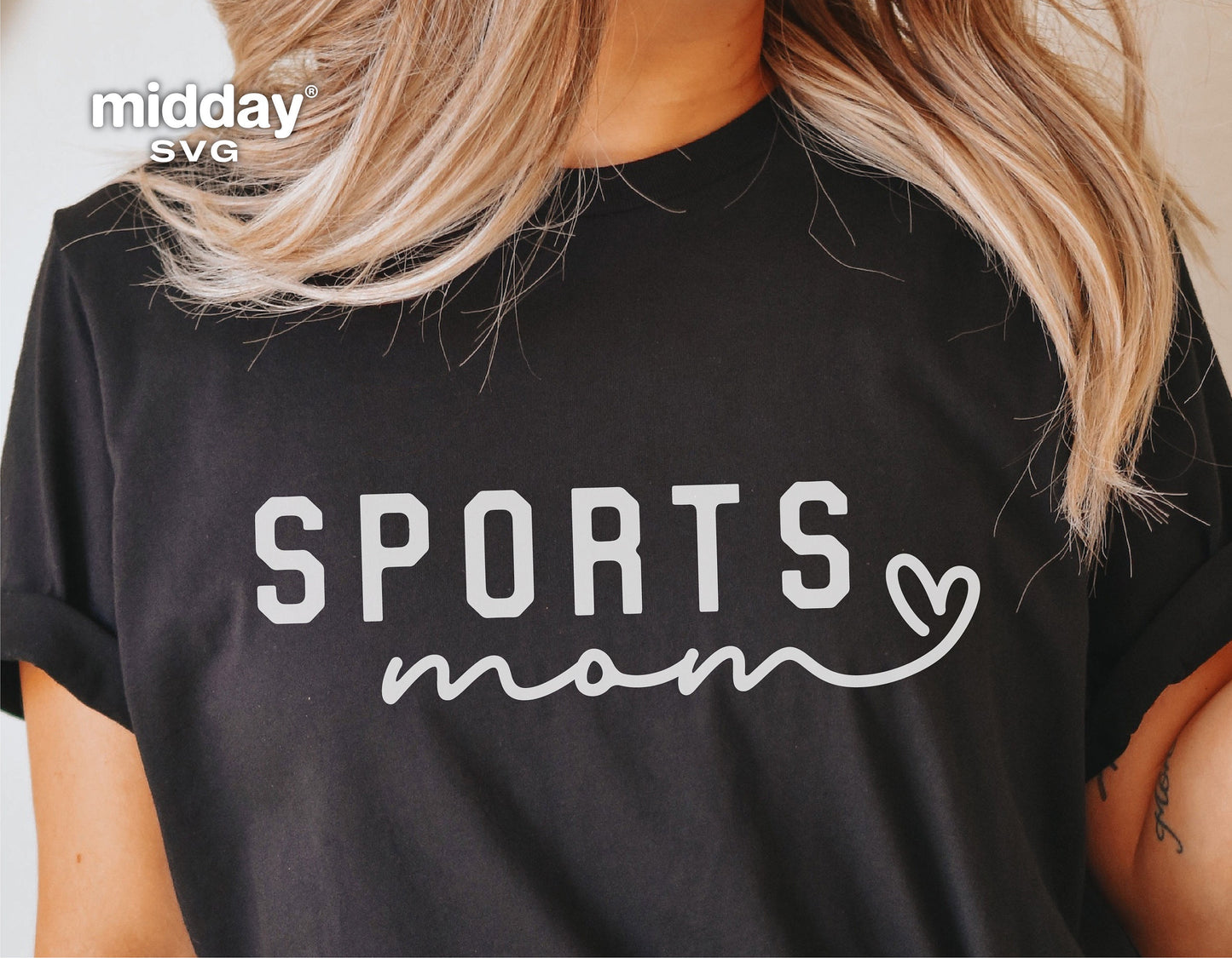 Woman wearing a black t-shirt with 'Sports Mom' print in white, perfect for sports enthusiasts using Cricut and Silhouette machines.
