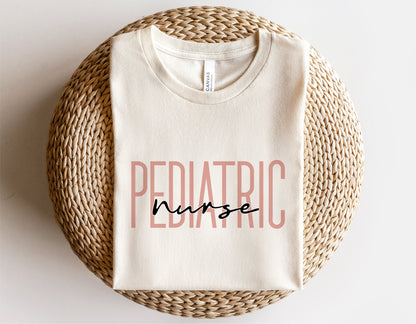 Cream t-shirt with 'Pediatric Nurse' text design, perfect for Cricut and Silhouette projects, displayed on a woven mat.