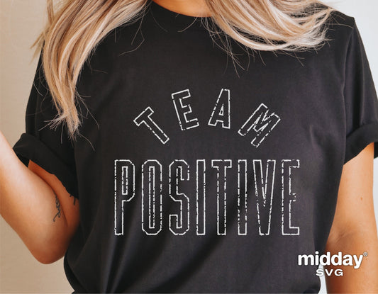 Woman wearing a black 'Team Positive' shirt, featuring an inspirational design for Cricut cutting. Ideal for motivational projects.