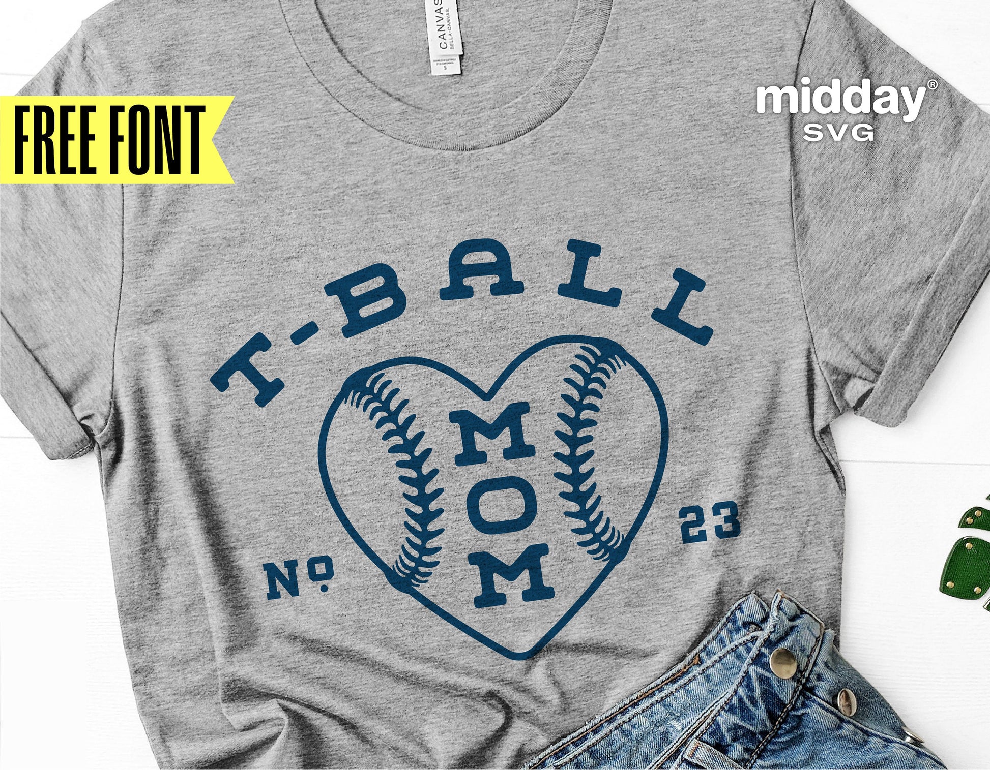 Gray t-shirt with 'T-Ball Mom' heart baseball design, surrounded by jeans. SVG cut file for Cricut and Silhouette crafts. Free font included.