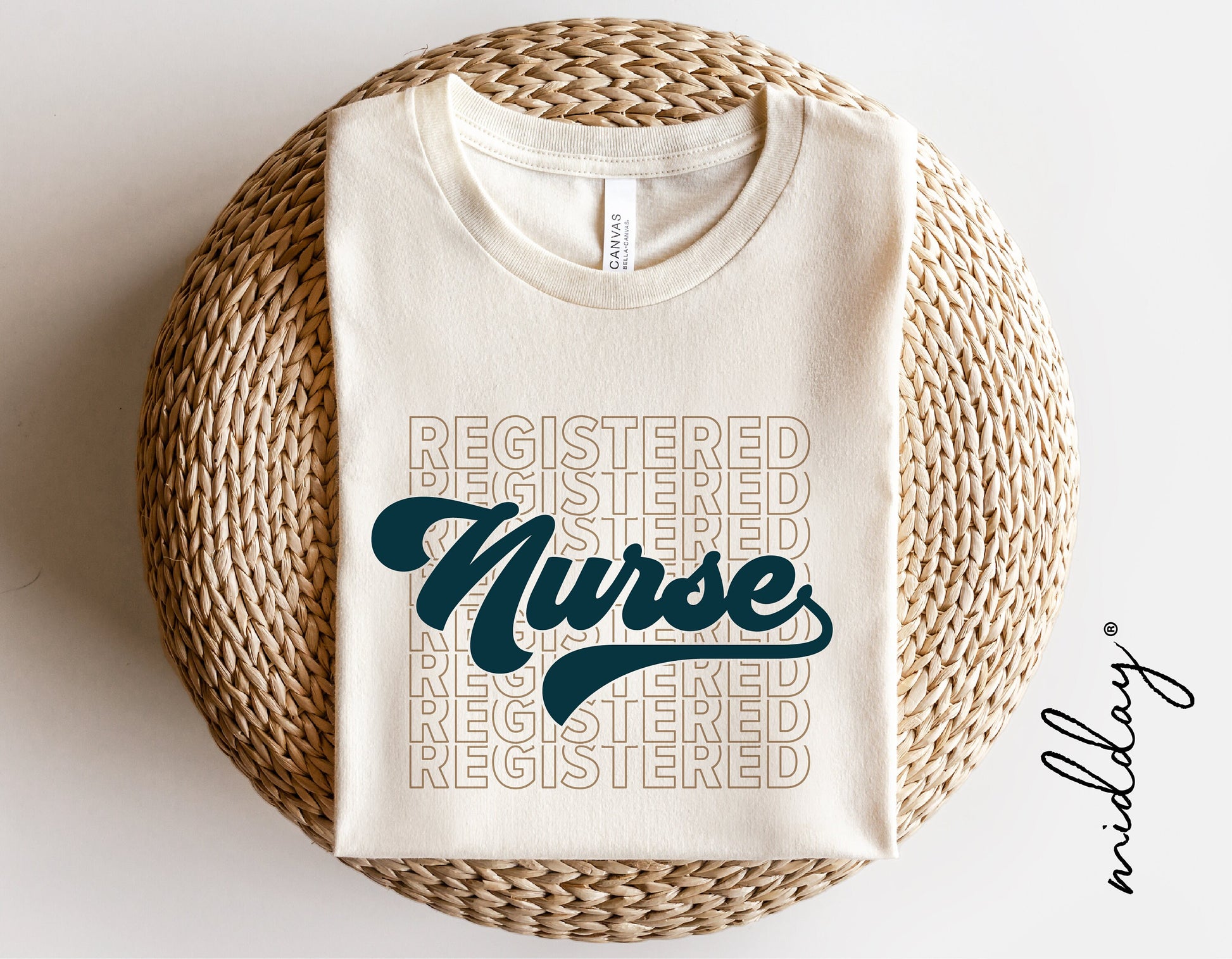 White t-shirt with 'Registered Nurse' design in teal and beige, folded on a woven surface, ideal gift for nurses.