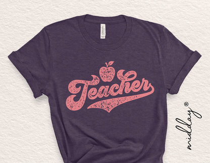 Purple t-shirt with a pink "Teacher" design featuring an apple, ideal for appreciation gifts, shirts, and crafting projects.