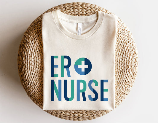 ER Nurse shirt with blue text and medical cross design folded on a woven basket, ideal for nurse-themed SVG projects.