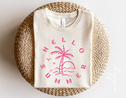 Hello Summer shirt with pink palm tree design, vacation-inspired fashion displayed on a woven basket.