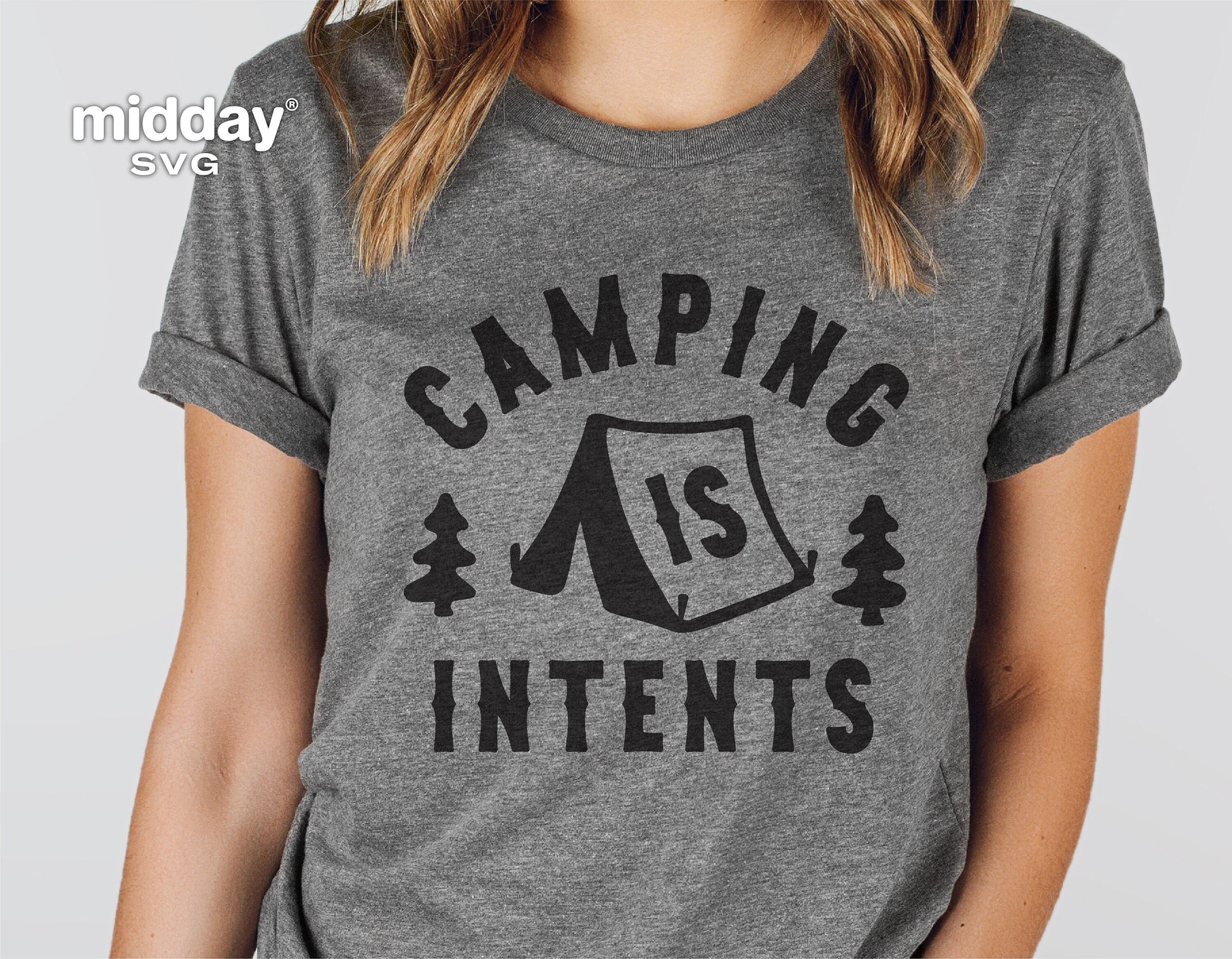 Person wearing a grey t-shirt with 'Camping Is Intents' graphic, showing a tent between two trees, ideal for camping enthusiasts.