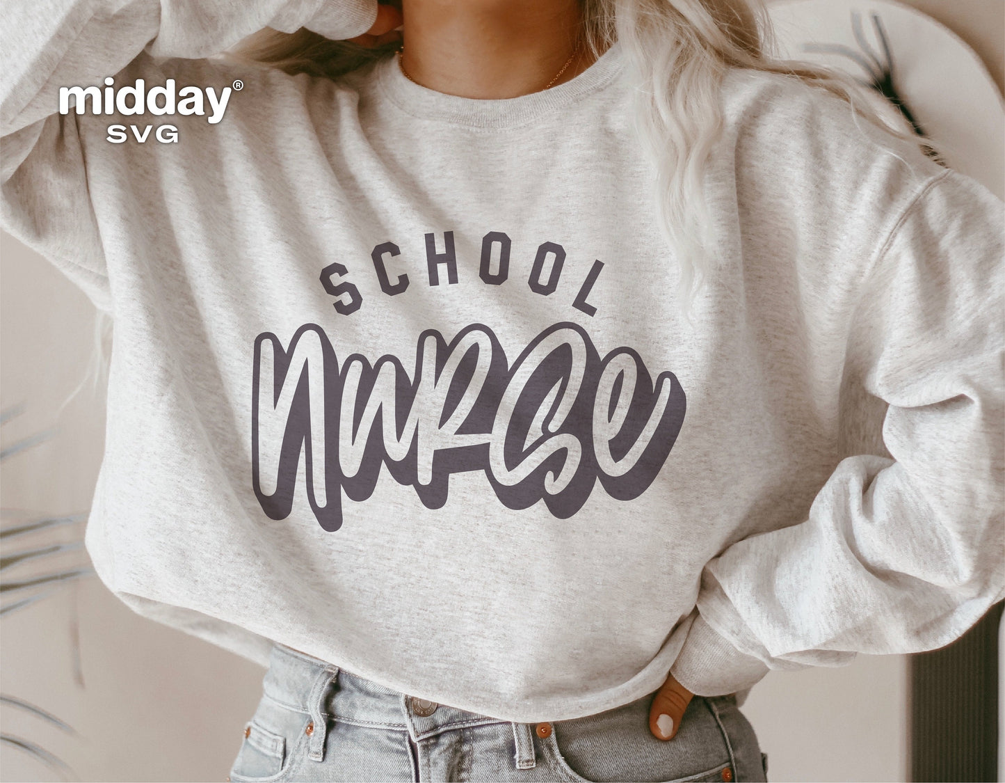 Woman wearing a beige sweatshirt with 'School Nurse' graphic design for DIY crafts, suitable for Cricut and Silhouette projects.