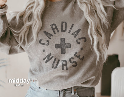 Person wearing a gray sweatshirt with 'Cardiac Nurse' graphic design, perfect for shirts and nursing professionals. SVG file available.