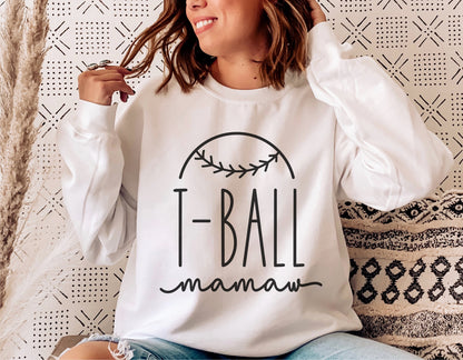 Woman wearing a white sweatshirt with "T-Ball mamaw" design, perfect for Cricut and Silhouette projects, featuring sporty baseball theme.