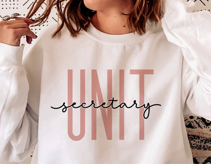 White sweatshirt with 'Unit Secretary' text in stylish pink and black font, perfect for hospital secretary appreciation.