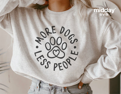 Person wearing sweater with 'More Dogs Less People' quote and paw print design, perfect for dog lovers and Cricut cutting projects.
