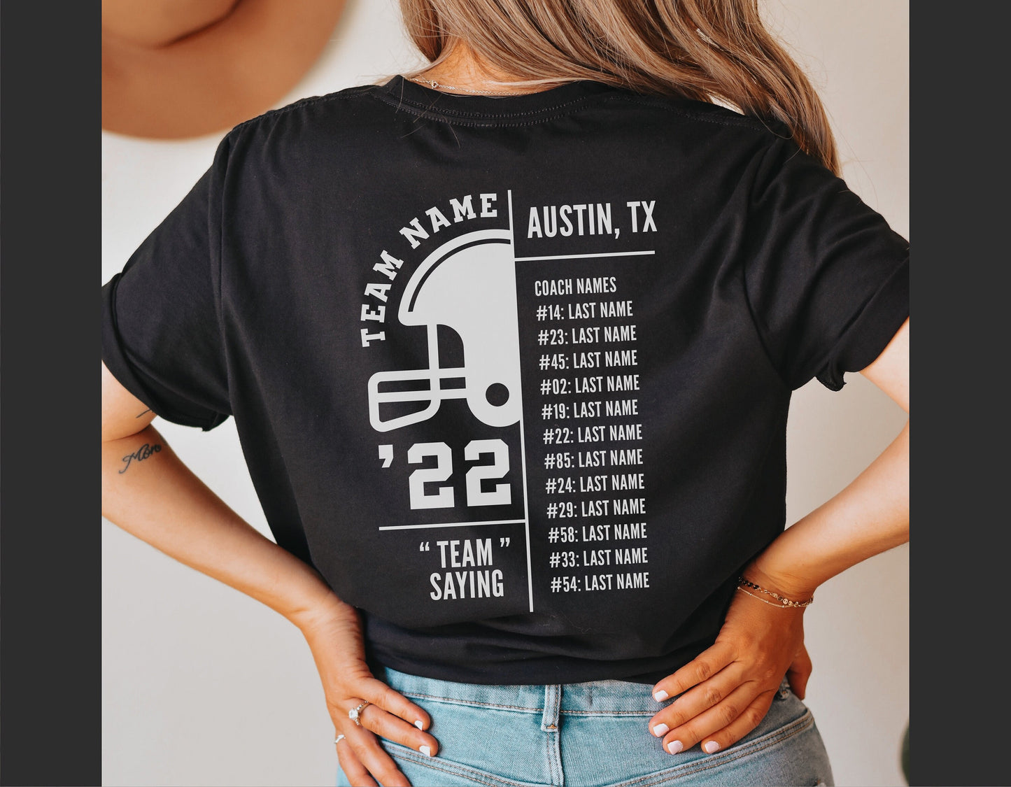 Back view of a woman wearing a personalized football roster t-shirt with team name and player numbers, ideal for sports events.
