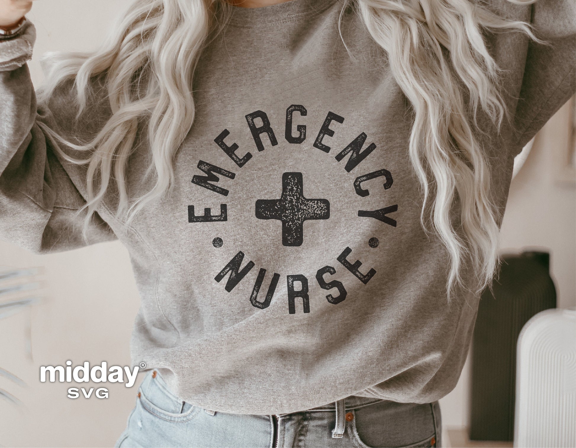 Woman wearing a gray sweatshirt with 'Emergency Nurse' text and a medical cross graphic.