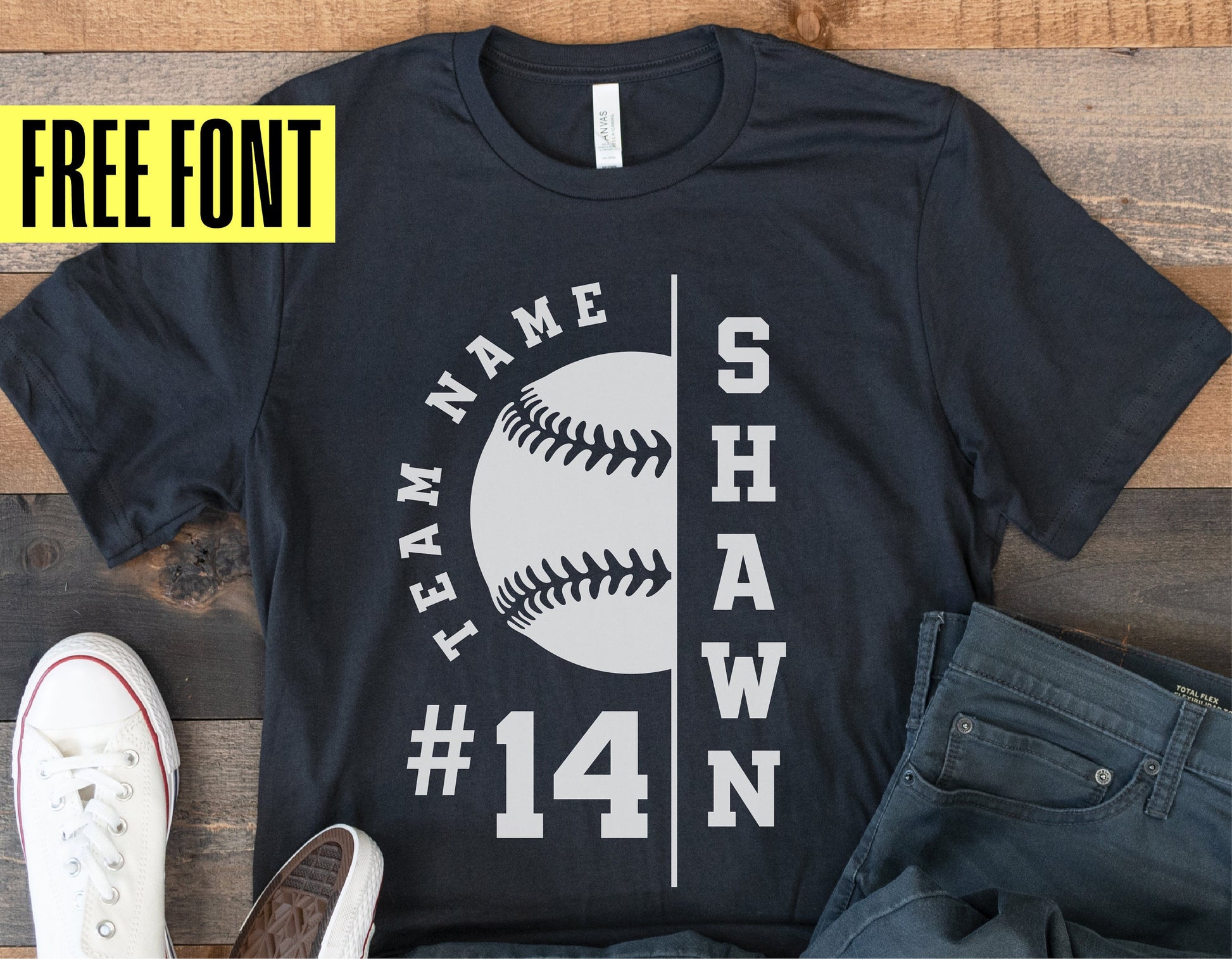 Black softball team shirt with custom name and number in white, featuring a baseball graphic, paired with casual shoes and jeans.