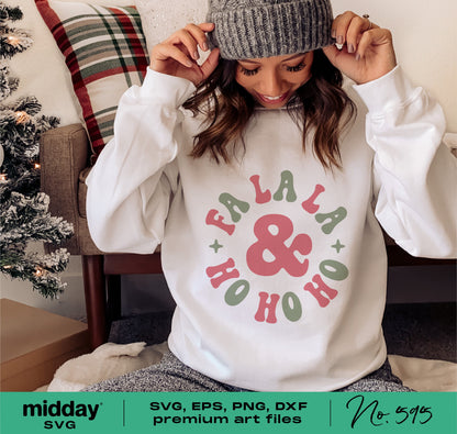 Woman wearing a white sweater with festive 'Fa La La & Ho Ho Ho' design, perfect for Christmas, shown near a holiday-themed setting. Ideal for Cricut and Silhouette projects.