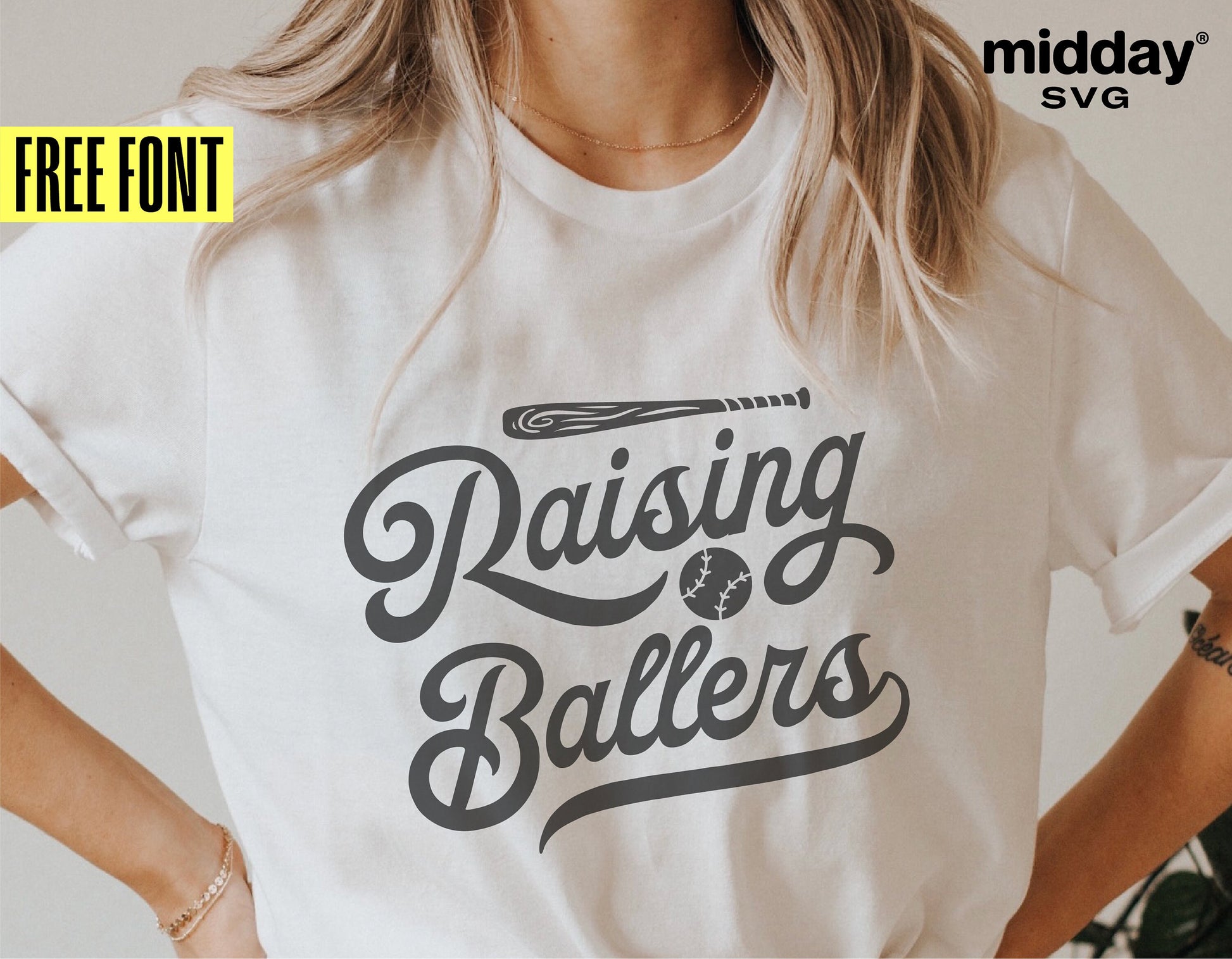 Person wearing 'Raising Ballers' baseball-themed t-shirt by Midday SVG, featuring script font and a baseball graphic.