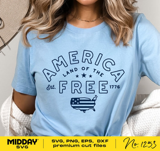 Woman wearing light blue t-shirt with 'America Land of the Free' design, featuring stars and USA map illustration, promoting freedom and patriotism.