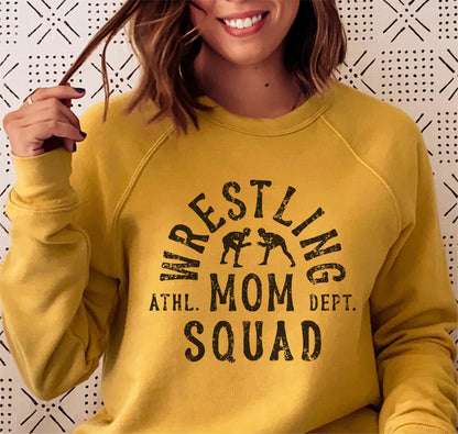 Woman wearing yellow 'Wrestling Mom Squad' sweater, perfect Cricut cut file for creating shirts, hoodies, and more.